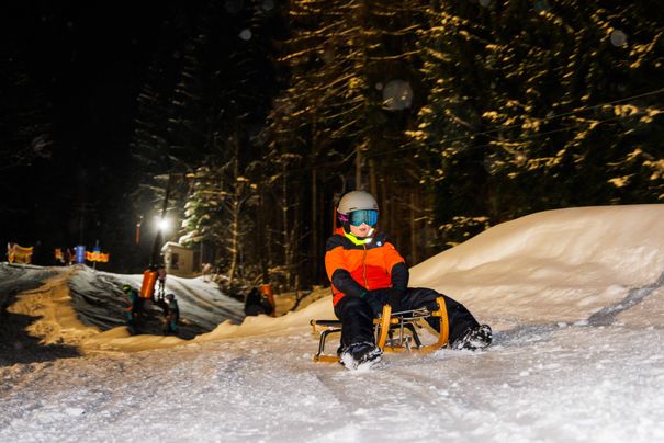 Kind beim Bergauf-Rodeln am Unternberg im Schnee