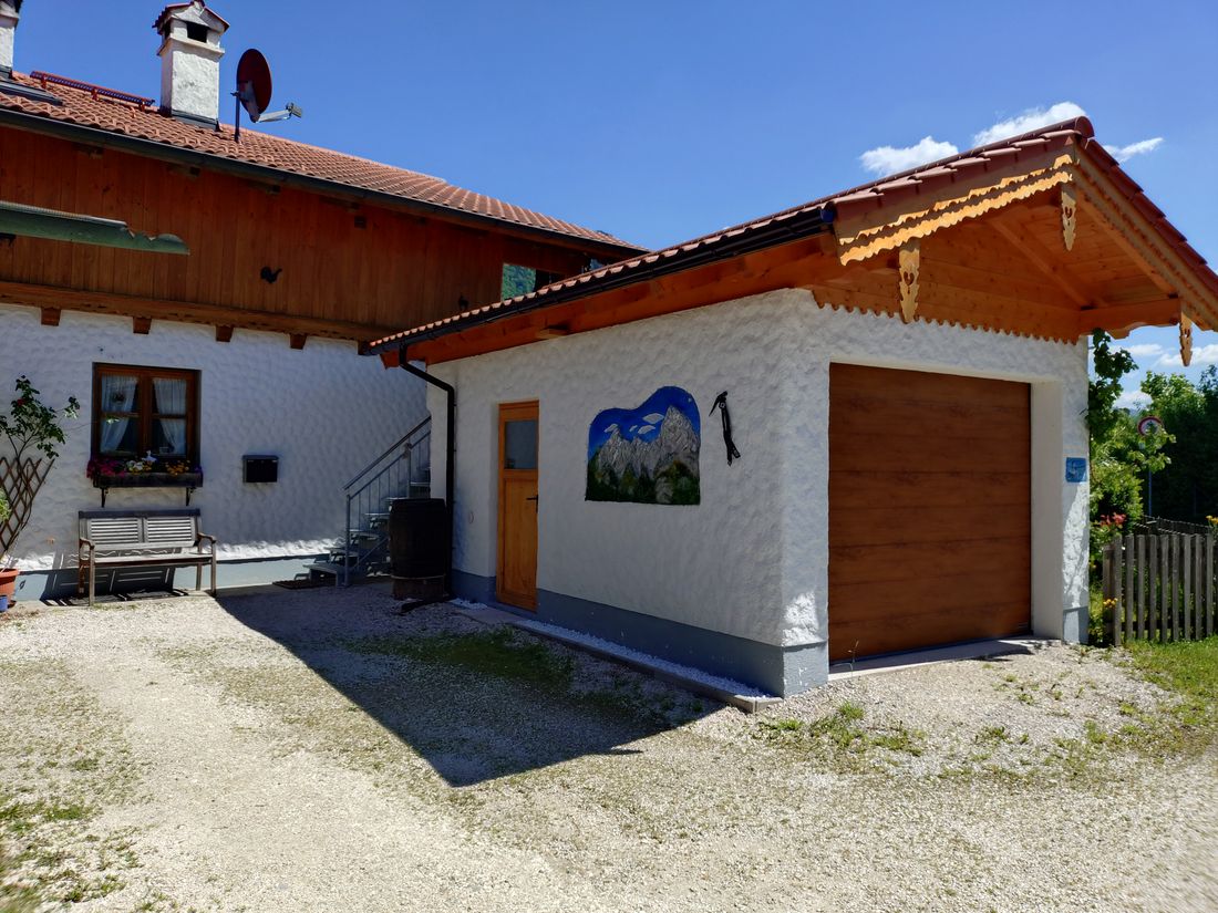 Gäste-Garage mit Elektro-Tor und Platz für Fahrräder, Treppenaufgang zur Ferienwohnung mit Balkon
